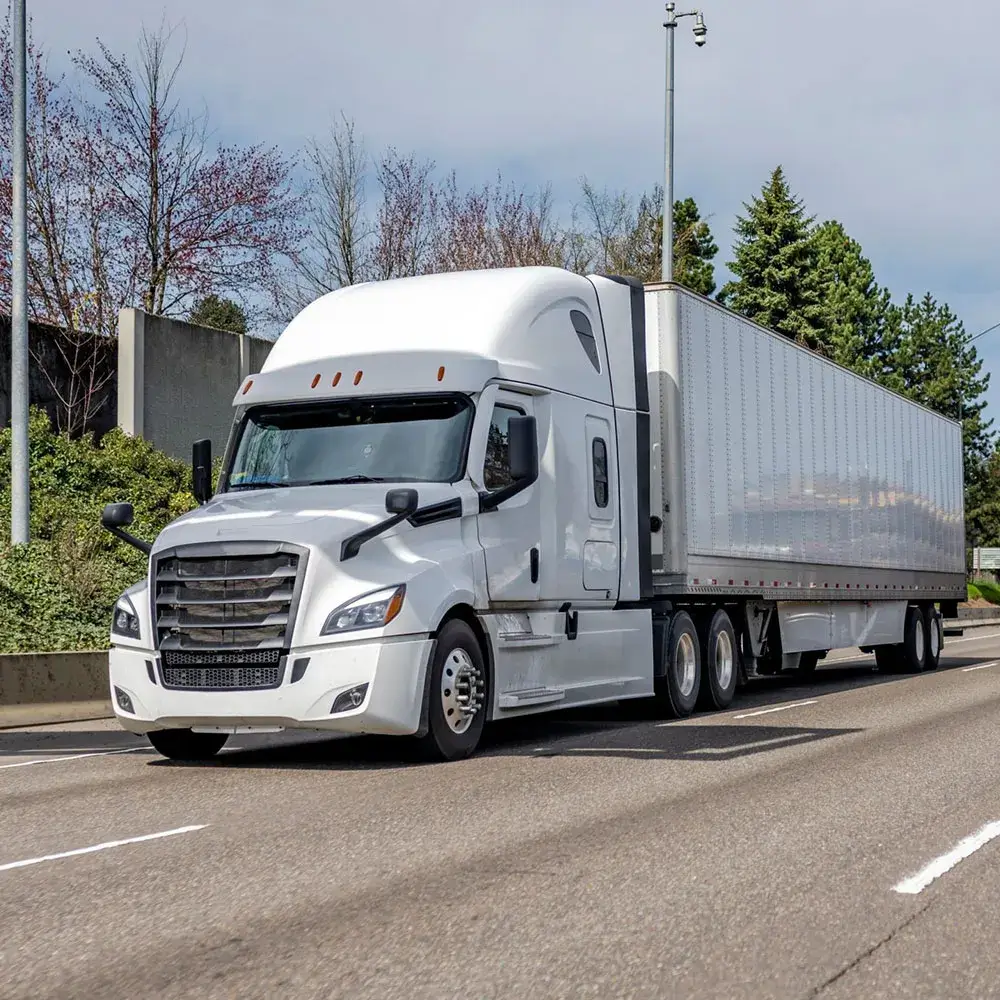 Transporting white semi truck transporting cargo